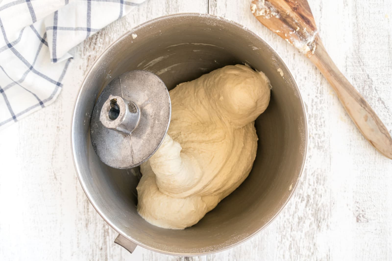 A stand mixer working dough on a warm home-kitchen counter